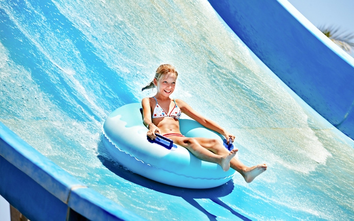Child enjoying a water slide at Ramayana Water Park.