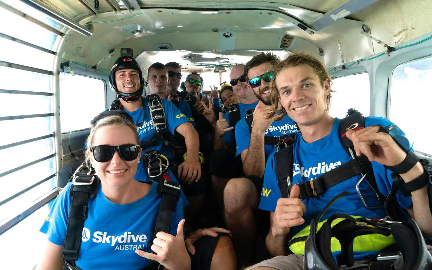 Skydivers in a plane preparing for tandem jump at Airlie Beach.