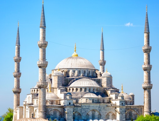 Blue Mosque with minarets in Istanbul, Turkey, surrounded by greenery.