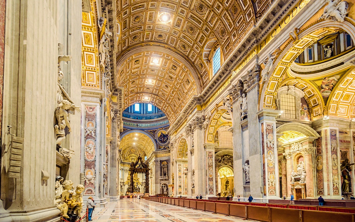 St. Peter's Basilica interior with ornate ceiling and columns in Vatican City.