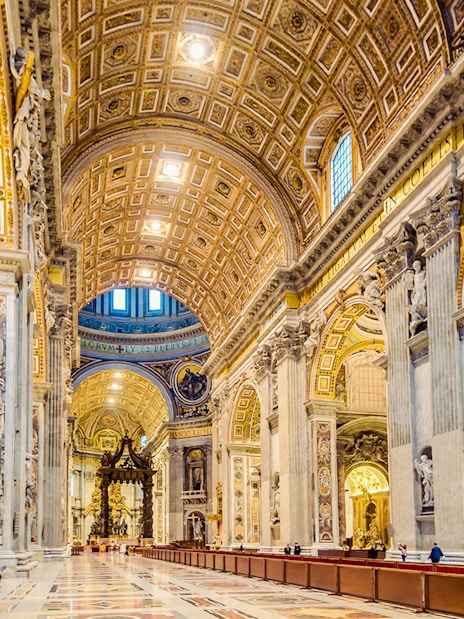 St. Peter's Basilica interior with ornate ceiling and columns in Vatican City.