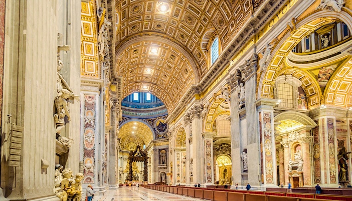 St. Peter's Basilica interior with ornate ceiling and columns in Vatican City.