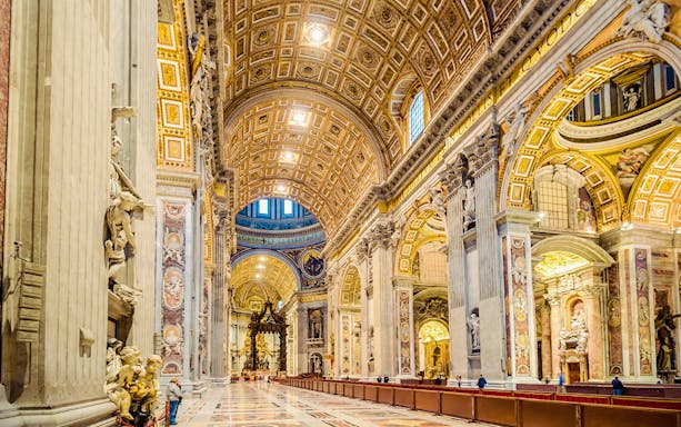 St. Peter's Basilica interior with ornate ceiling and columns in Vatican City.