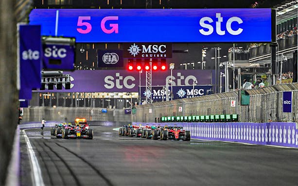 Formula 1 cars racing at Saudi Arabia Grand Prix night event, March 2023.