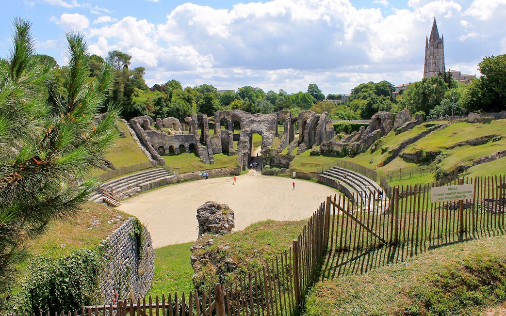 Ancient Roman amphitheater in the Latin Quarter, Paris, with surrounding greenery.