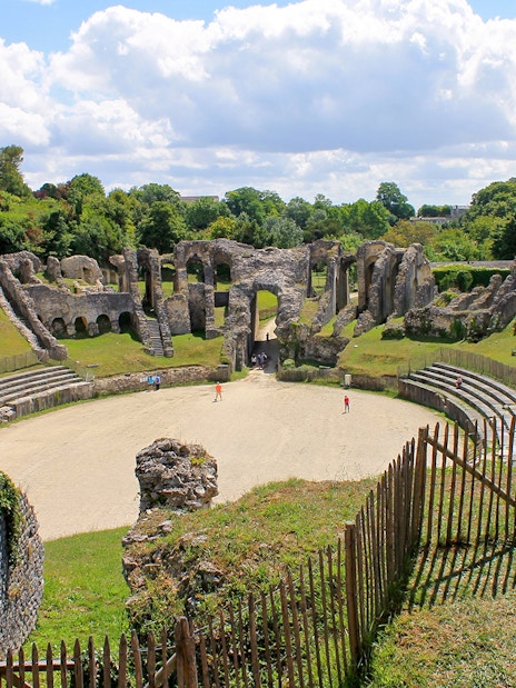 Ancient Roman amphitheater in the Latin Quarter, Paris, with surrounding greenery.