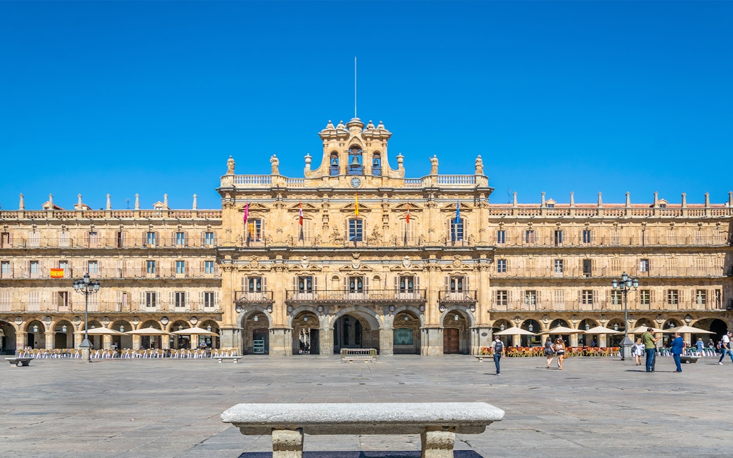 Tourists walking in Plaza Mayor, Salamanca, Spain, with historic architecture in the background.