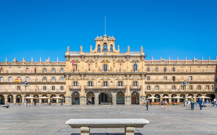 Tourists walking in Plaza Mayor, Salamanca, Spain, with historic architecture in the background.