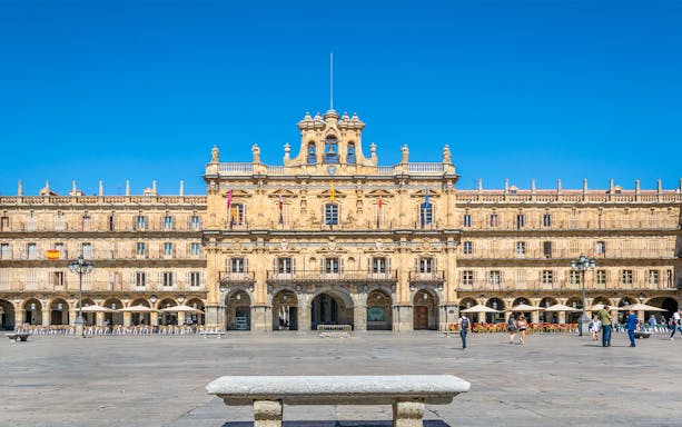 Tourists walking in Plaza Mayor, Salamanca, Spain, with historic architecture in the background.