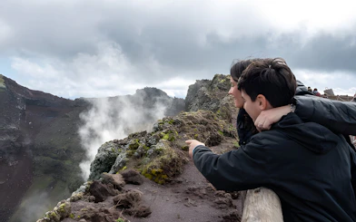 Tour group observing volcanic landscape at Vesuvius National Park near Naples, Italy.