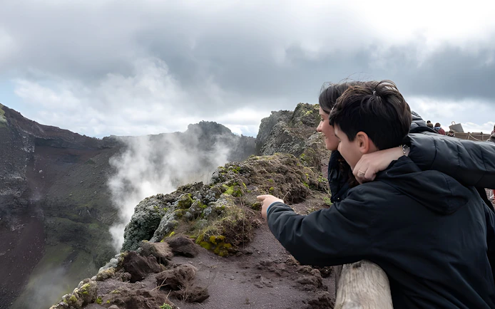 Tour group observing volcanic landscape at Vesuvius National Park near Naples, Italy.