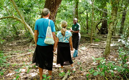 Guide leading a tour through Kaya Kinondo Forest, Diani Beach.