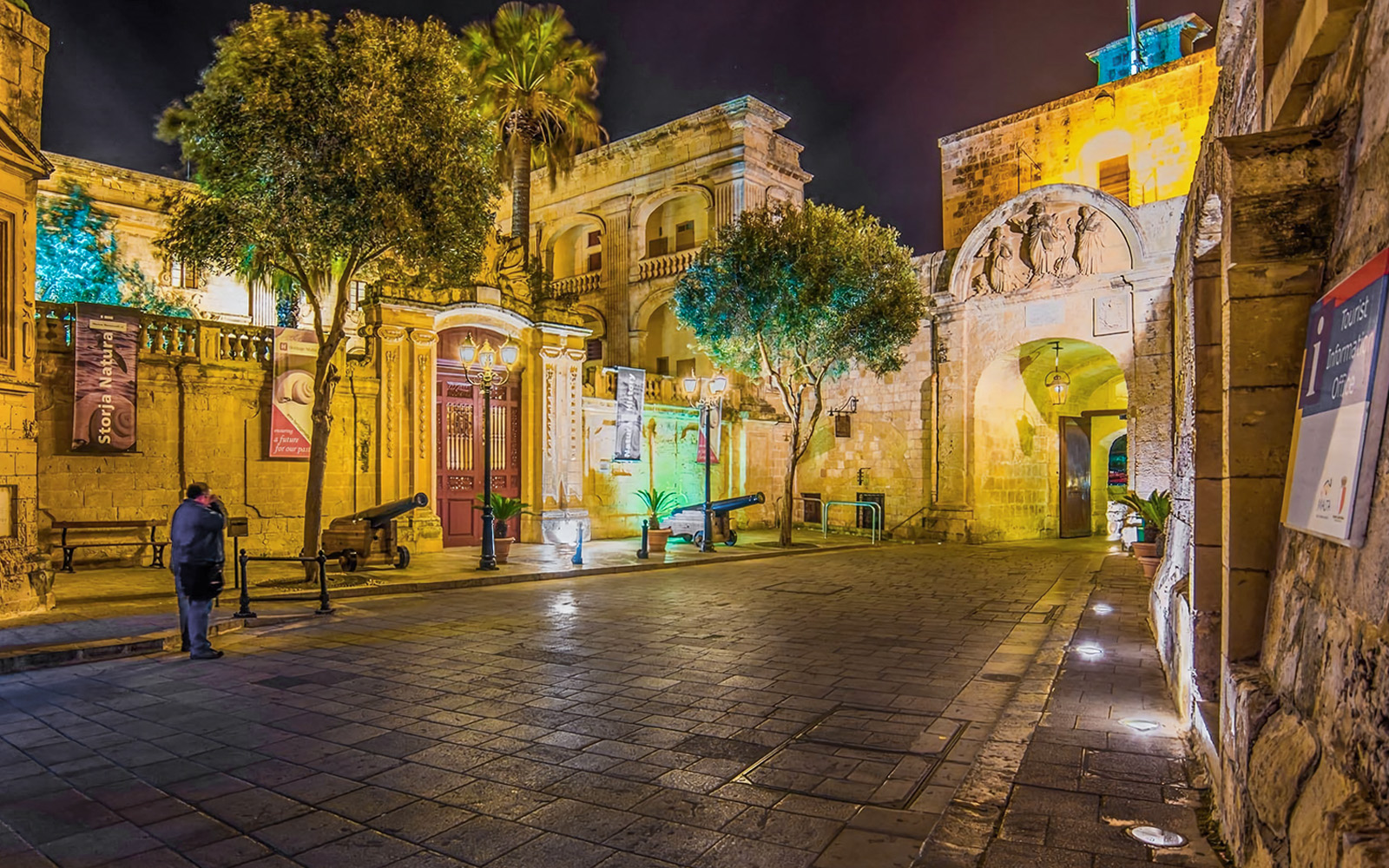Historic street in Malta illuminated at night during a guided tour.