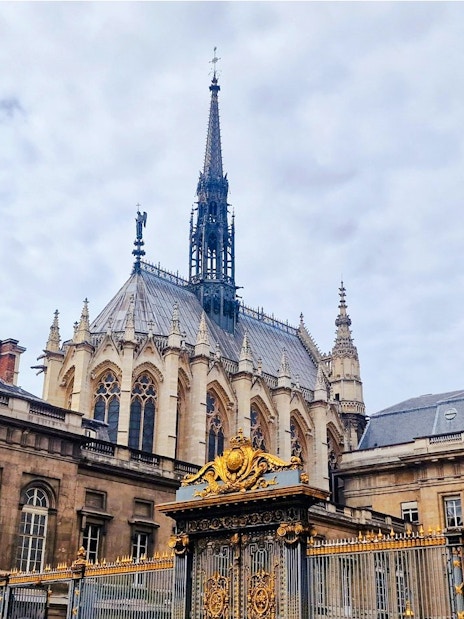Sainte-Chapelle exterior with ornate spire and golden gate in Paris, France.