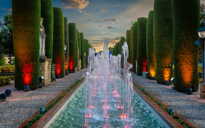 Fountain illuminated at night in the Alcazar of Cordoba garden, Spain.