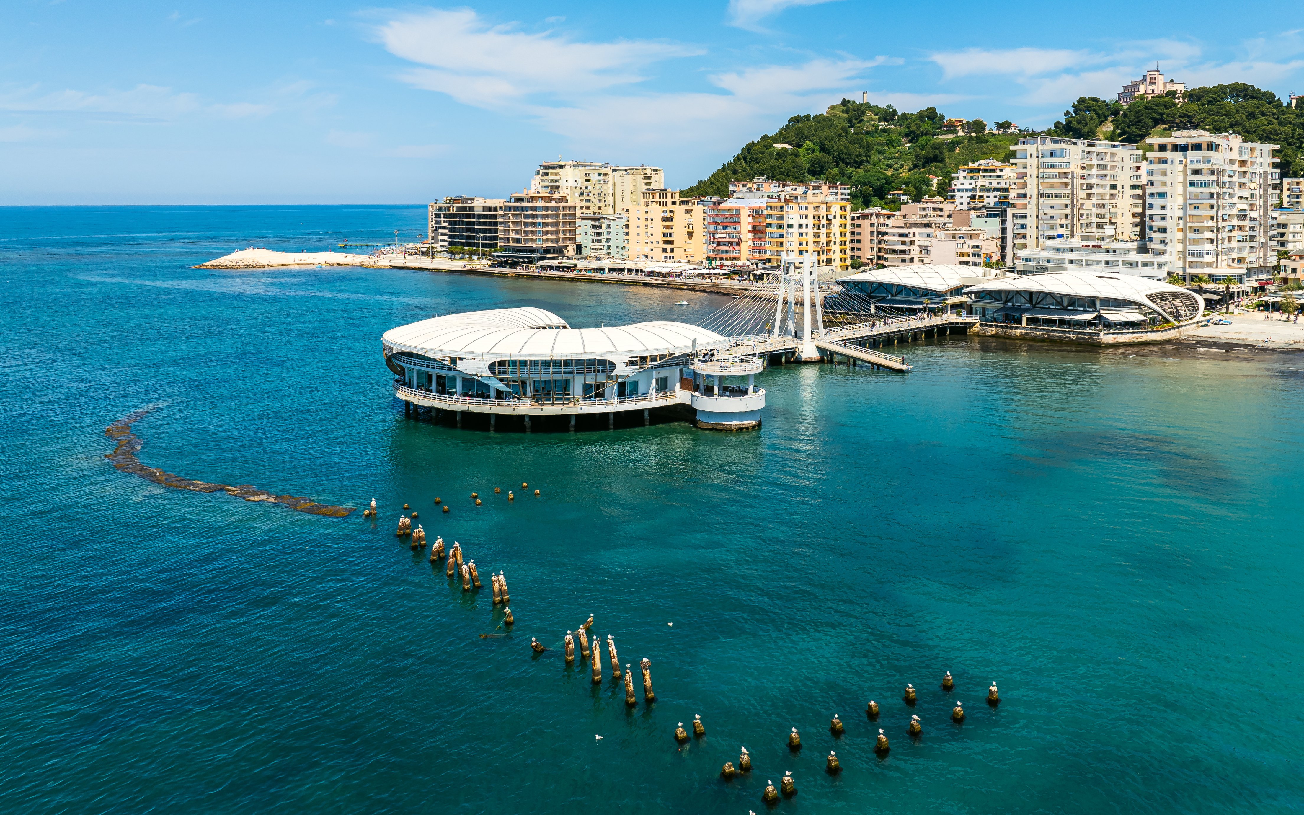 Ventus Harbor in Albania with modern waterfront buildings and clear blue sea.