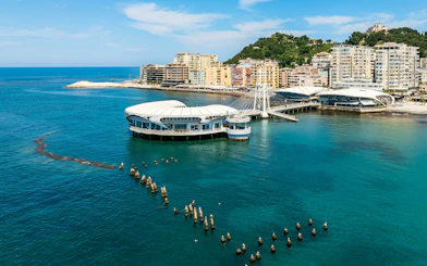 Ventus Harbor in Albania with modern waterfront buildings and clear blue sea.