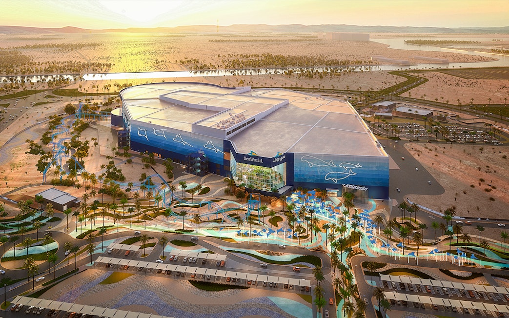 SeaWorld Abu Dhabi exterior with desert landscape and parking area.