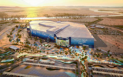 SeaWorld Abu Dhabi exterior with desert landscape and parking area.