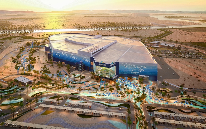 SeaWorld Abu Dhabi exterior with desert landscape and parking area.