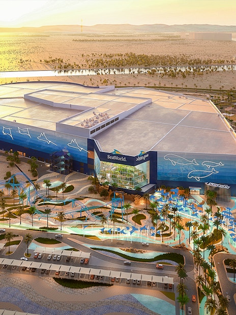 SeaWorld Abu Dhabi exterior with desert landscape and parking area.