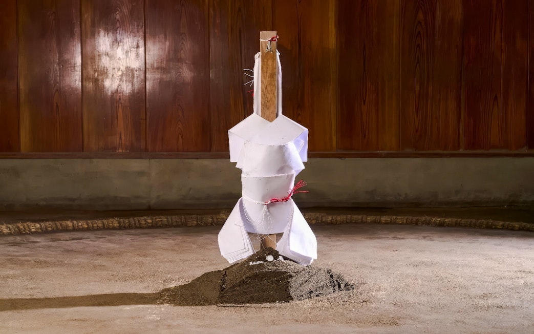 Sumo wrestling arena with wooden pillar and sand mound in Japan.