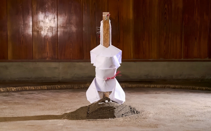 Sumo wrestling arena with wooden pillar and sand mound in Japan.