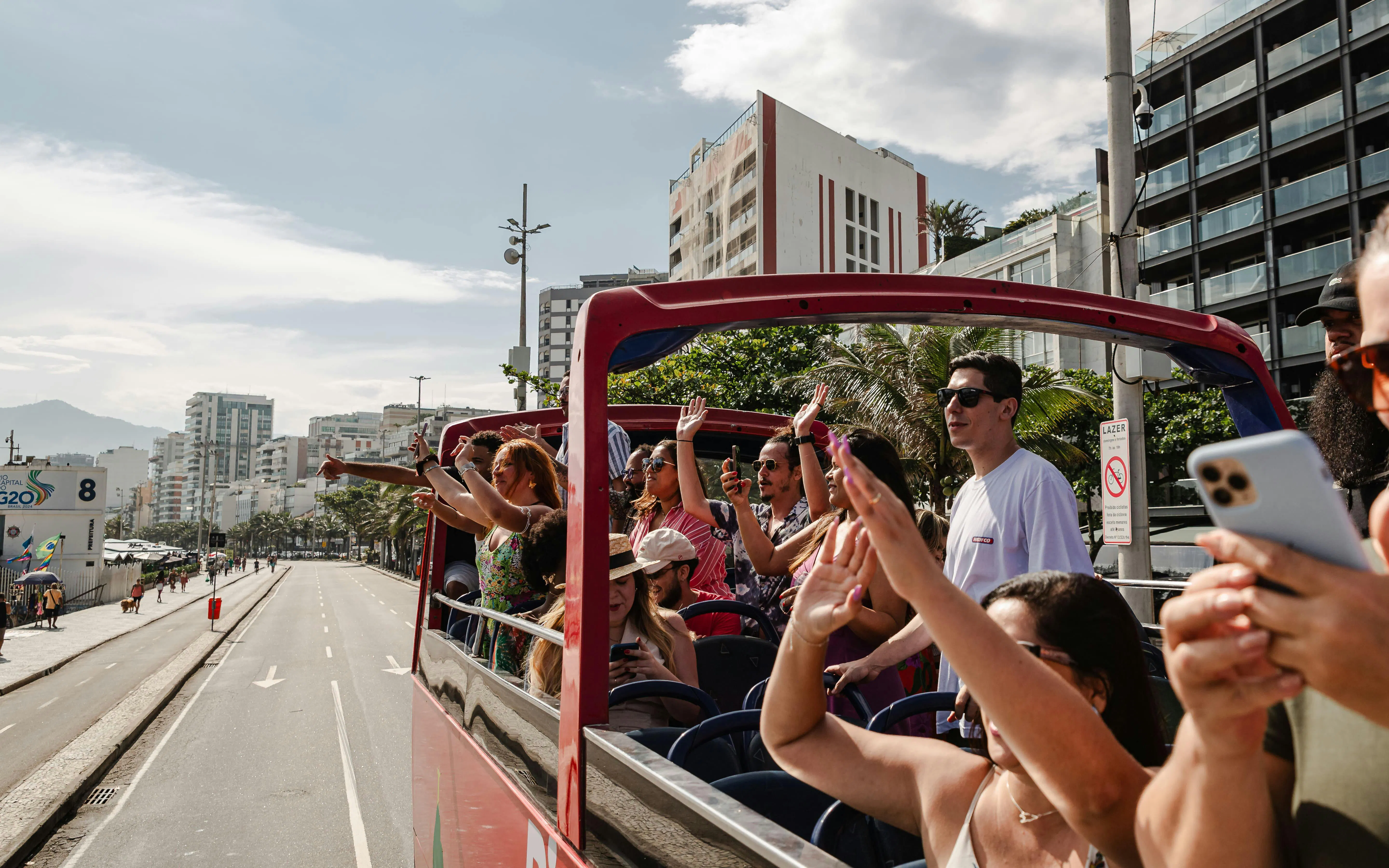 Tourists on an open-top bus enjoying Rio de Janeiro's cityscape during a hop-on hop-off tour.