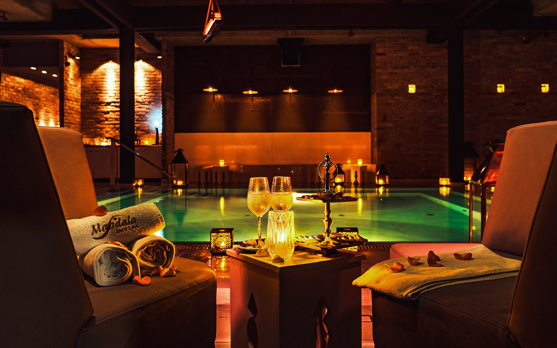 Luxurious poolside setting at Mandala Day Spa with towels and drinks.