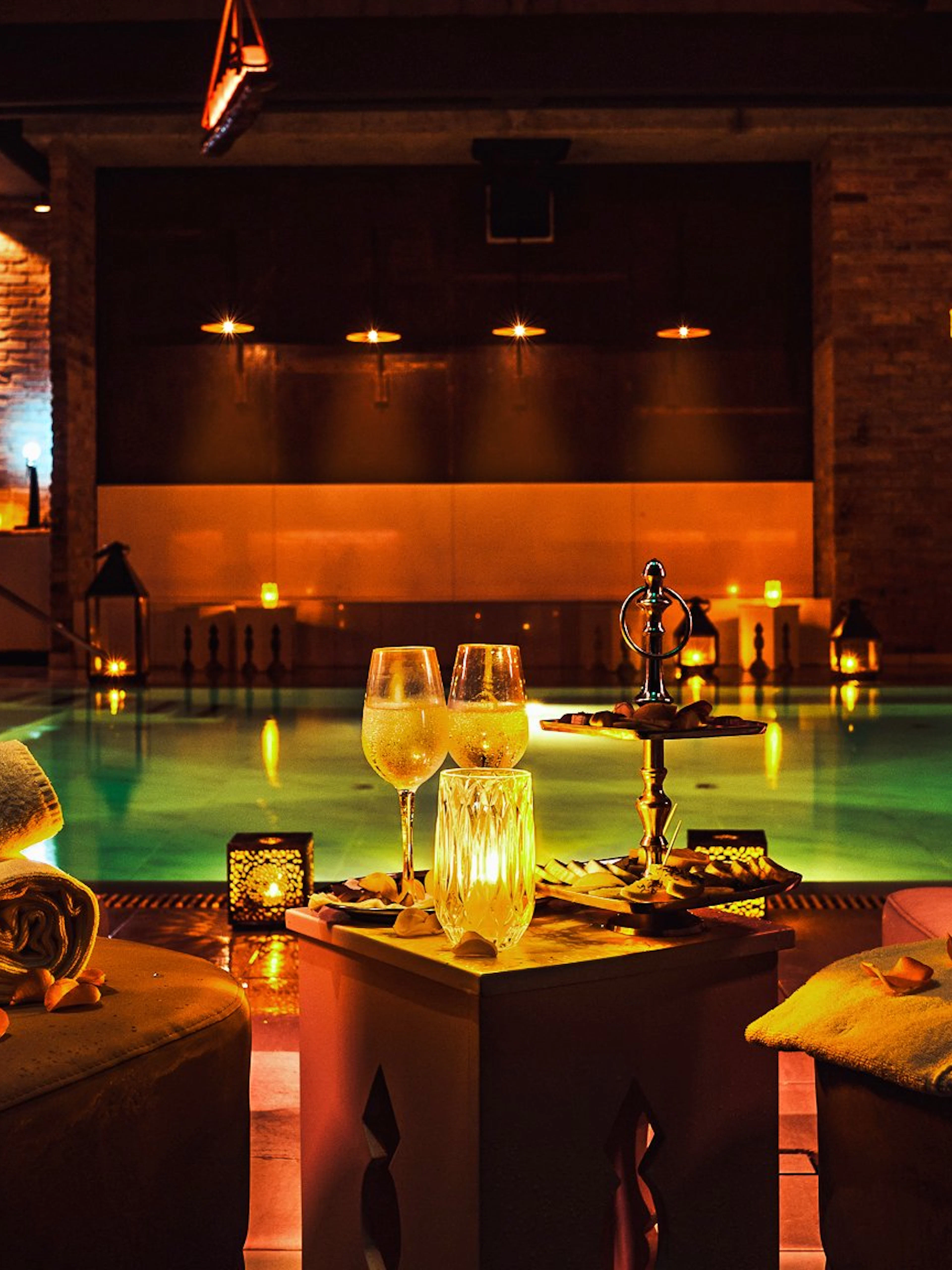 Luxurious poolside setting at Mandala Day Spa with towels and drinks.