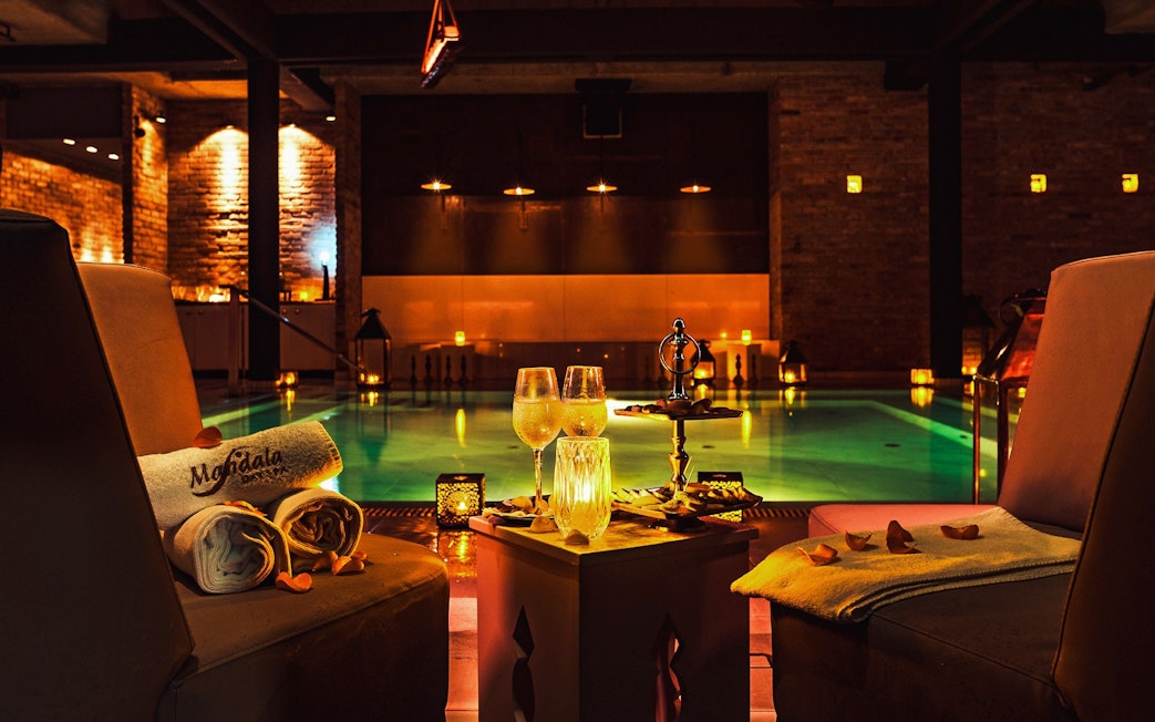 Luxurious poolside setting at Mandala Day Spa with towels and drinks.