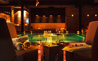 Luxurious poolside setting at Mandala Day Spa with towels and drinks.