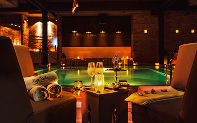 Luxurious poolside setting at Mandala Day Spa with towels and drinks.