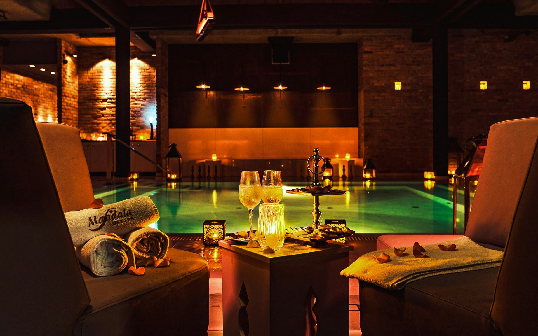 Luxurious poolside setting at Mandala Day Spa with towels and drinks.