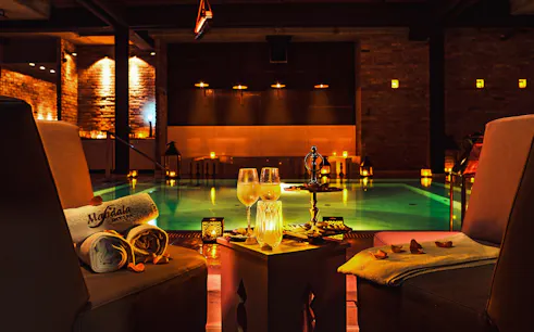 Luxurious poolside setting at Mandala Day Spa with towels and drinks.