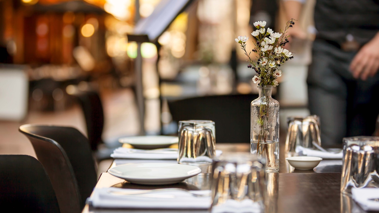 Dining table set with plates and glasses in a Melbourne restaurant.