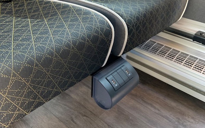 USB charging ports under a seat on the SIT shuttle bus from Fiumicino Airport to Rome city center.