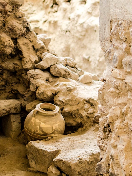 Ancient pottery and stone walls at Akrotiri Archaeological Site, Santorini.