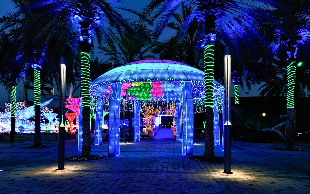 Illuminated pavilion and palm trees at Glow Garden, Dubai.