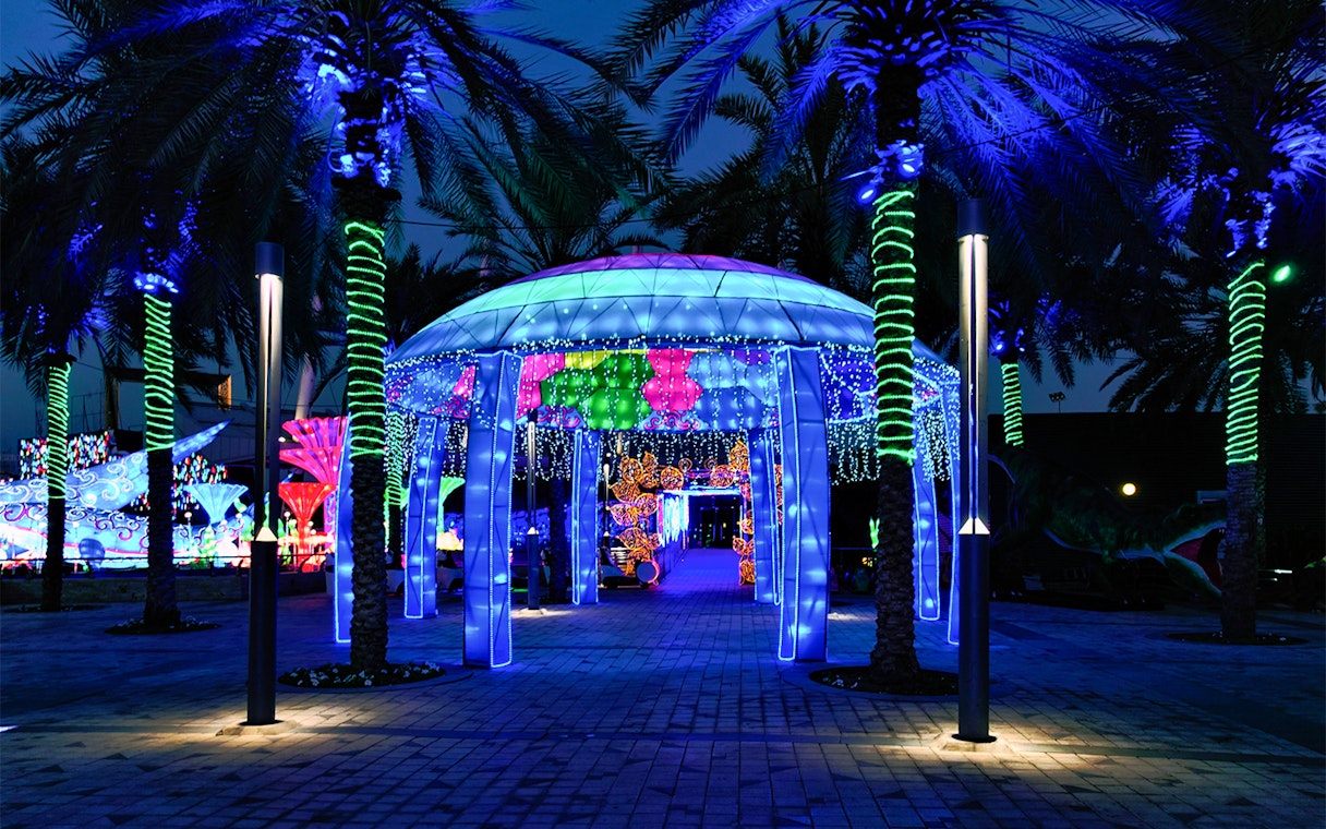 Illuminated pavilion and palm trees at Glow Garden, Dubai.