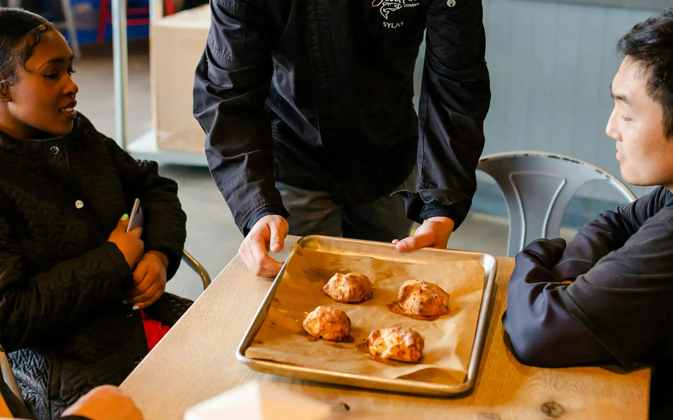 Chef presenting baked goods to guests on Pike Place Market food tour.