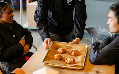 Chef presenting baked goods to guests on Pike Place Market food tour.