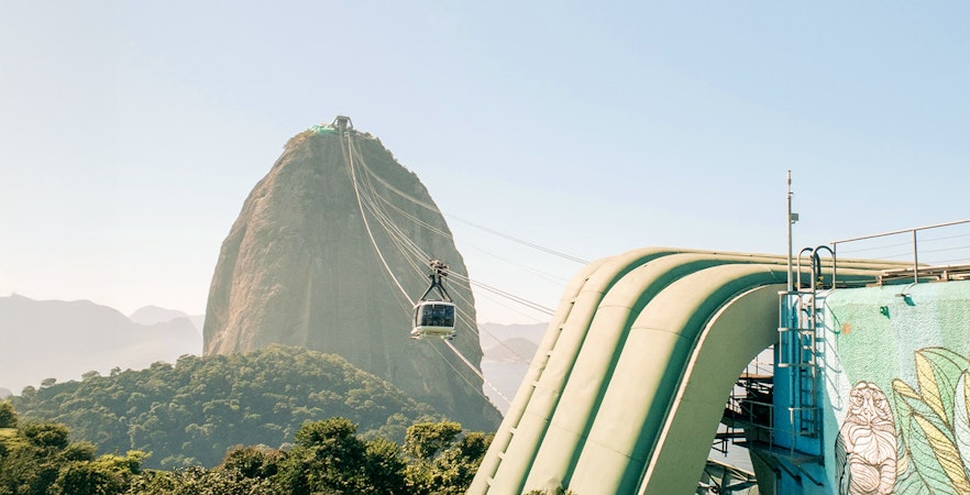 Cable car departing for Sugarloaf Mountain, Rio de Janeiro, with cityscape and ocean view.