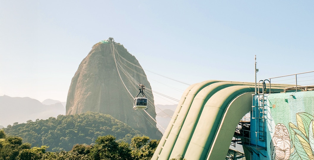 Cable car departing for Sugarloaf Mountain, Rio de Janeiro, with cityscape and ocean view.