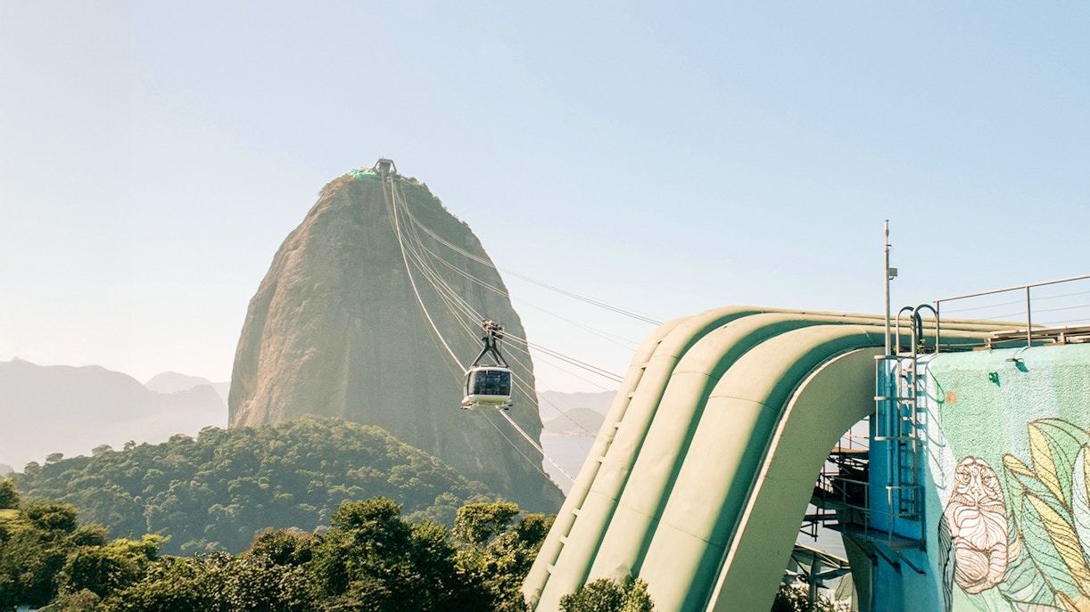 Cable car departing for Sugarloaf Mountain, Rio de Janeiro, with cityscape and ocean view.
