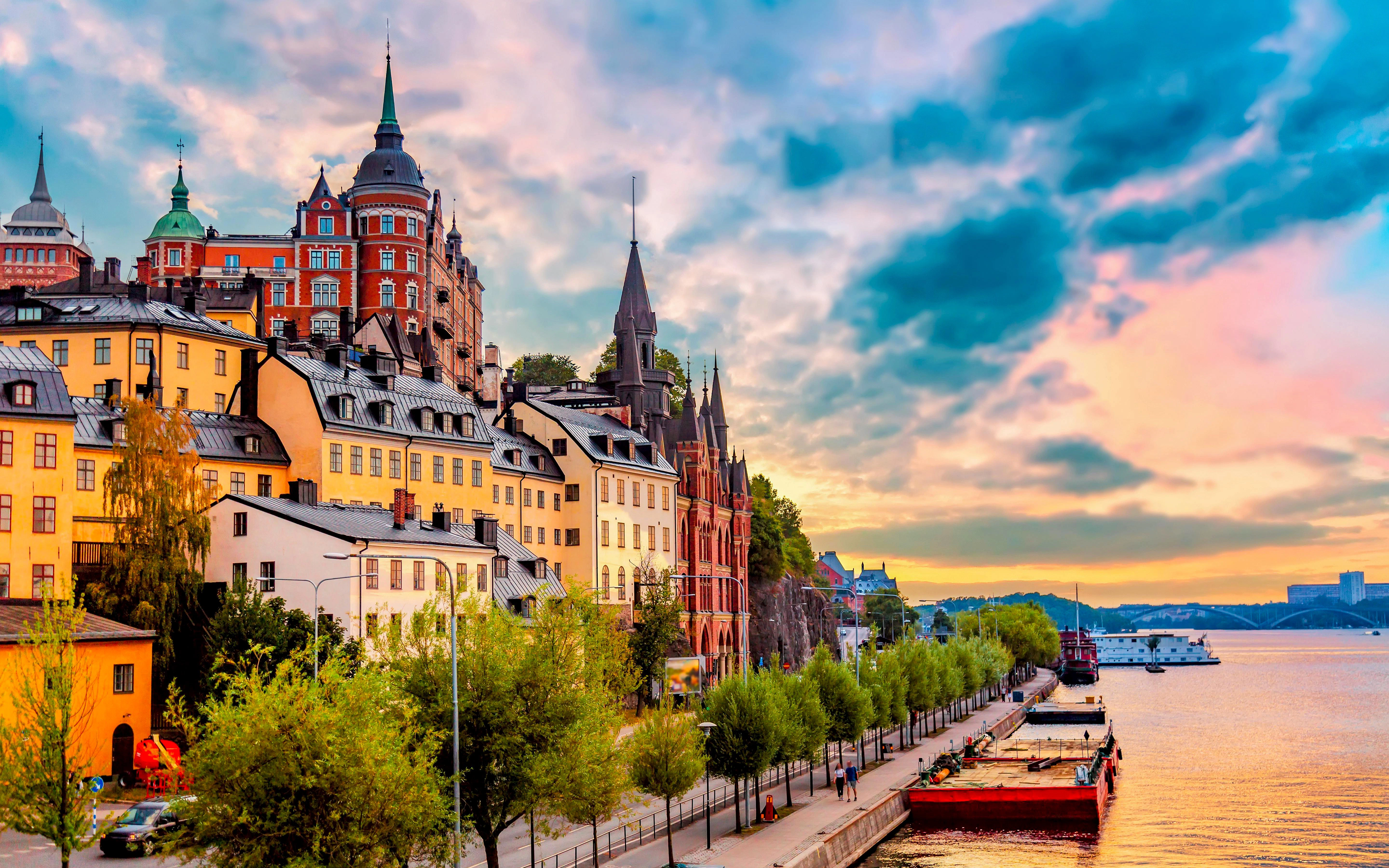 Scenic view of Stockholm waterfront with colorful buildings and boats at sunset.