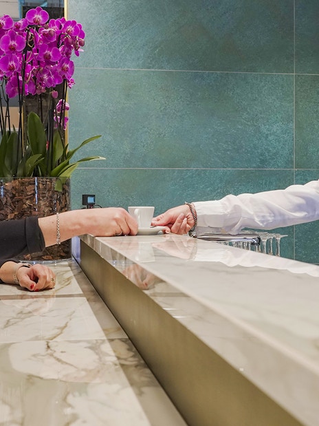Customer receiving a drink at Rome Fiumicino Airport premium lounge counter.