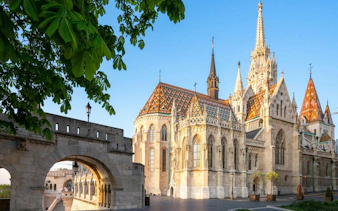 Fisherman's Bastion and Matthias Church in Budapest, Hungary, under a clear blue sky.