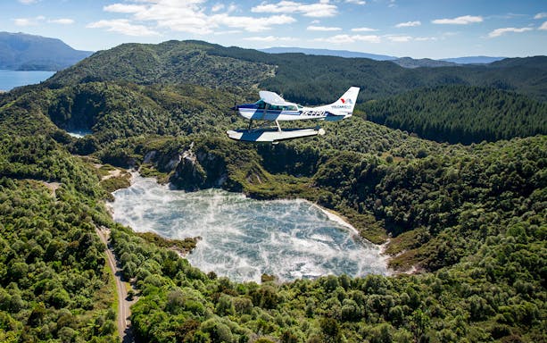 Floatplane flying over Orakei Korako geothermal area near Mount Tarawera, New Zealand.