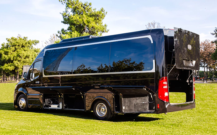Tour bus for Grand Canyon West Sunset Experience parked on grass.